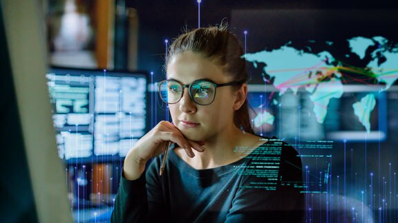 Woman sitting at a table looking at automation data